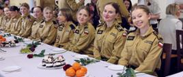 Kawiarnia Centralnej Szkoły PSP w czasie spotkania z okazji Dnia Kobiet, na pierwszym planie siedzący za stołem uśmiechnięte kadetki Centralnej Szkoły PSP