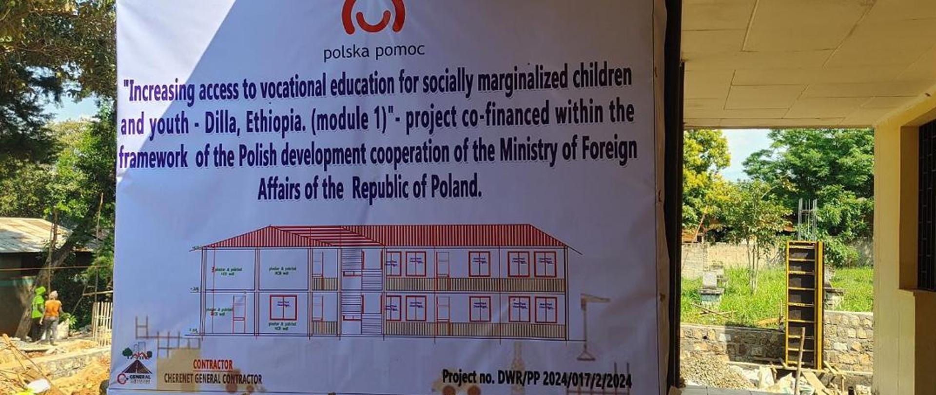 Tablica z projektem szkoły, informacją po angielsku o współfinansowaniu projektu przez MSZ oraz z logo Polskiej pomocy