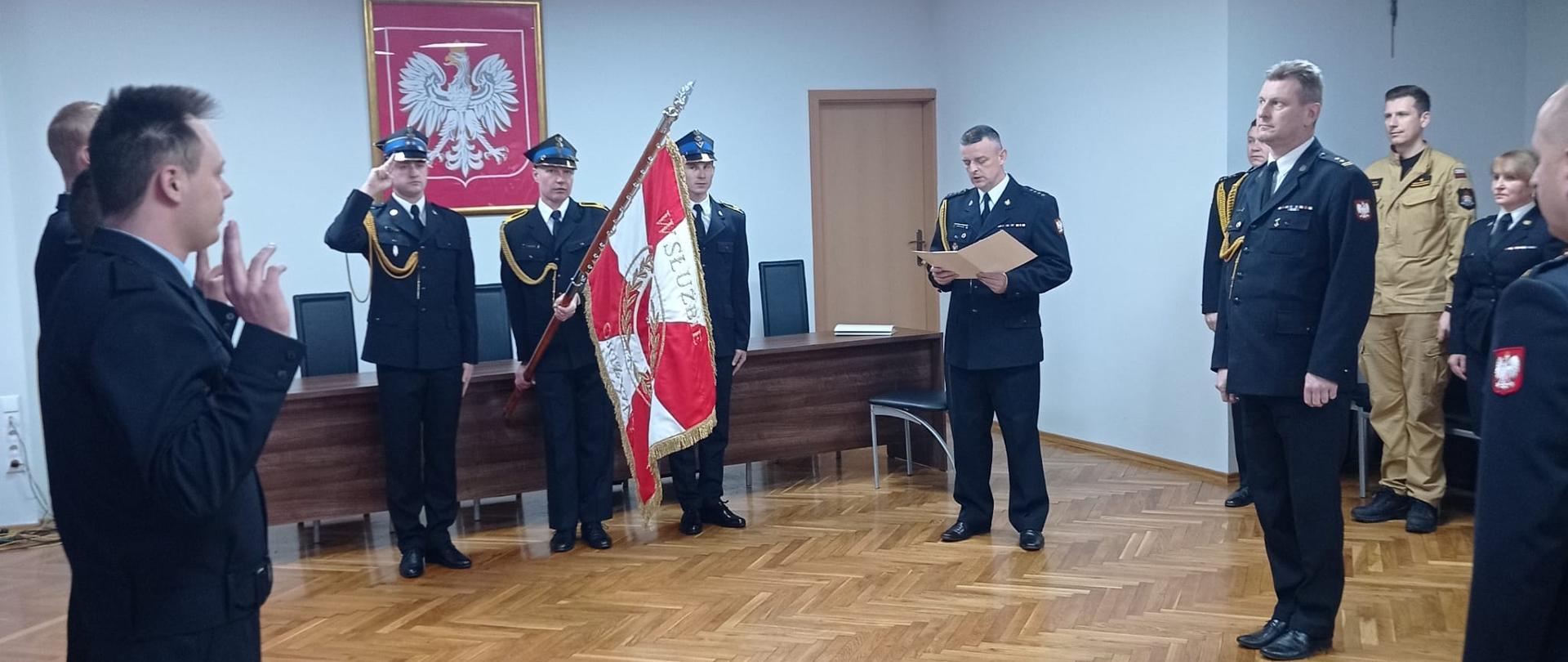 Na zdjęciu poczet sztandarowy Komendy Miejskiej Państwowej Straży Pożarnej w Częstochowie, trzech nowoprzyjętych stażystów składających ślubowanie, które przyjmuje Komendant Miejski Państwowej Straży Pożarnej w Częstochowie - brygadier Marek Radosz.