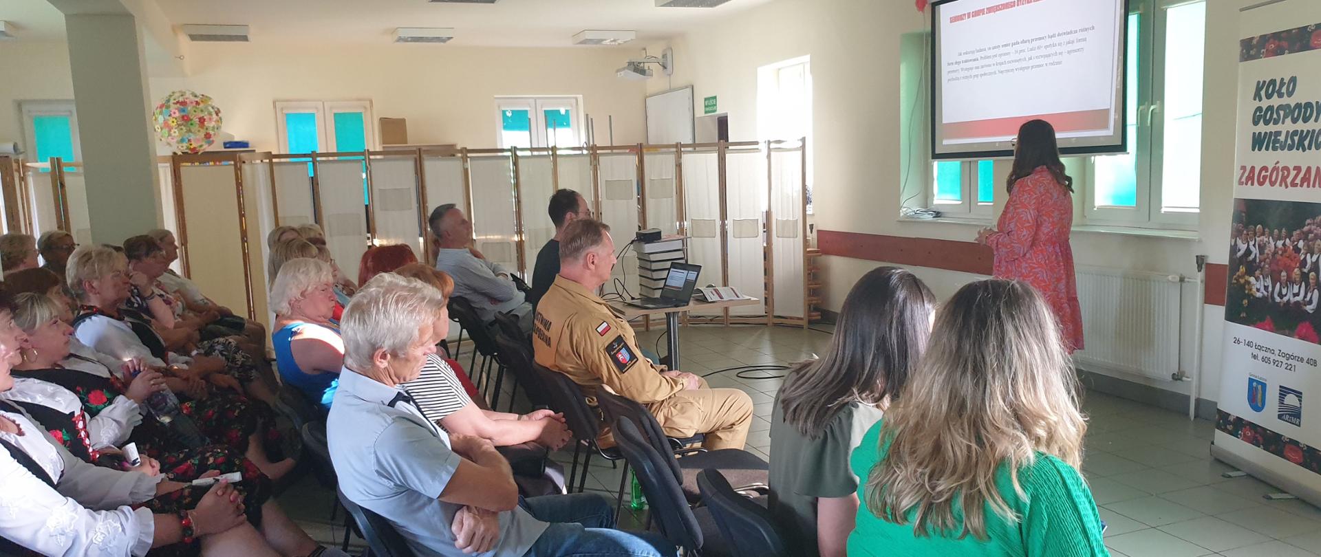 Seniorki słuchają pani psycholog mówiącej o przemocy domowej