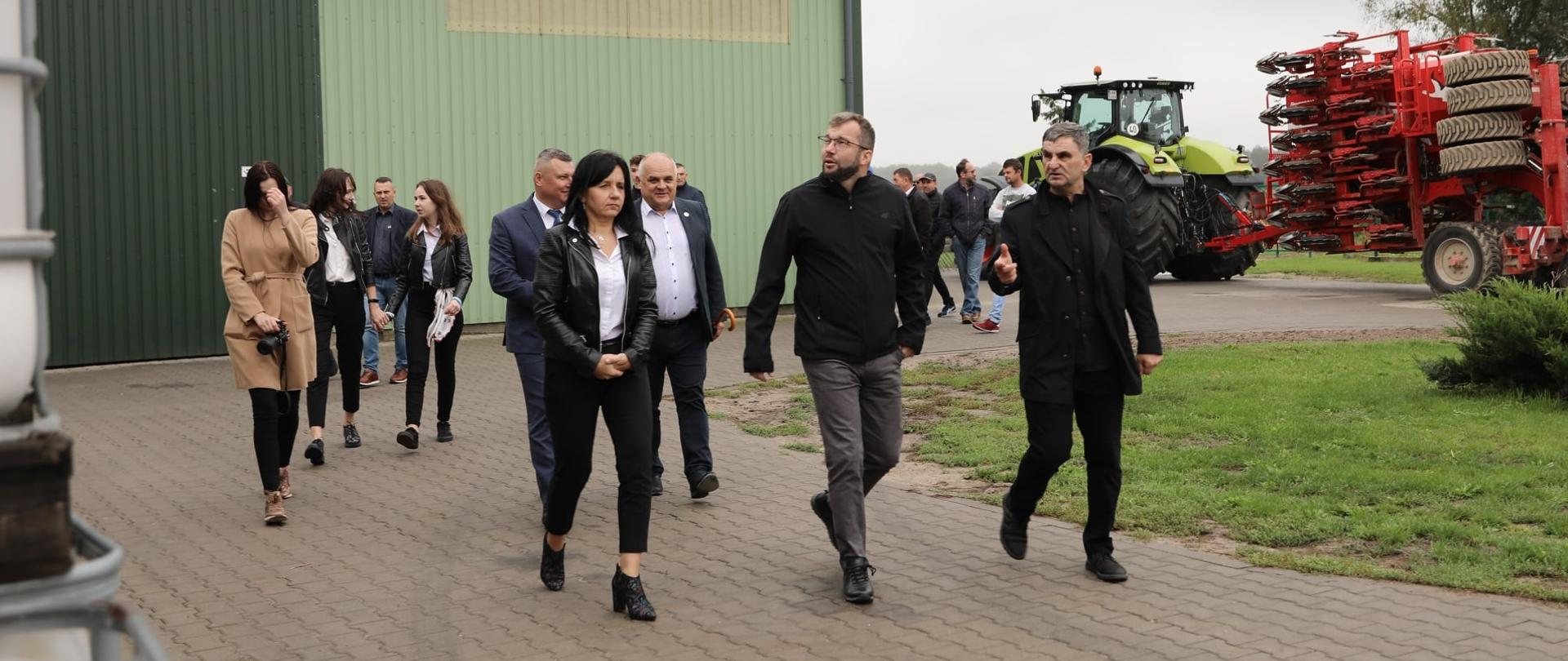 Minister Grzegorz Puda zwiedzający gospodarstwo rolne.