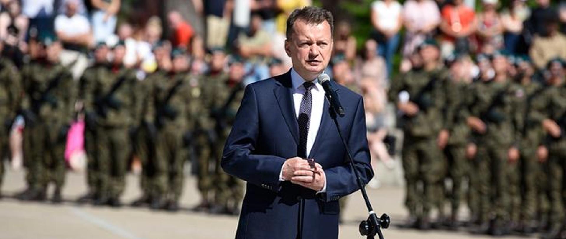 Jeden mężczyzna stojący przed mikrofonem i wypowiadający się 