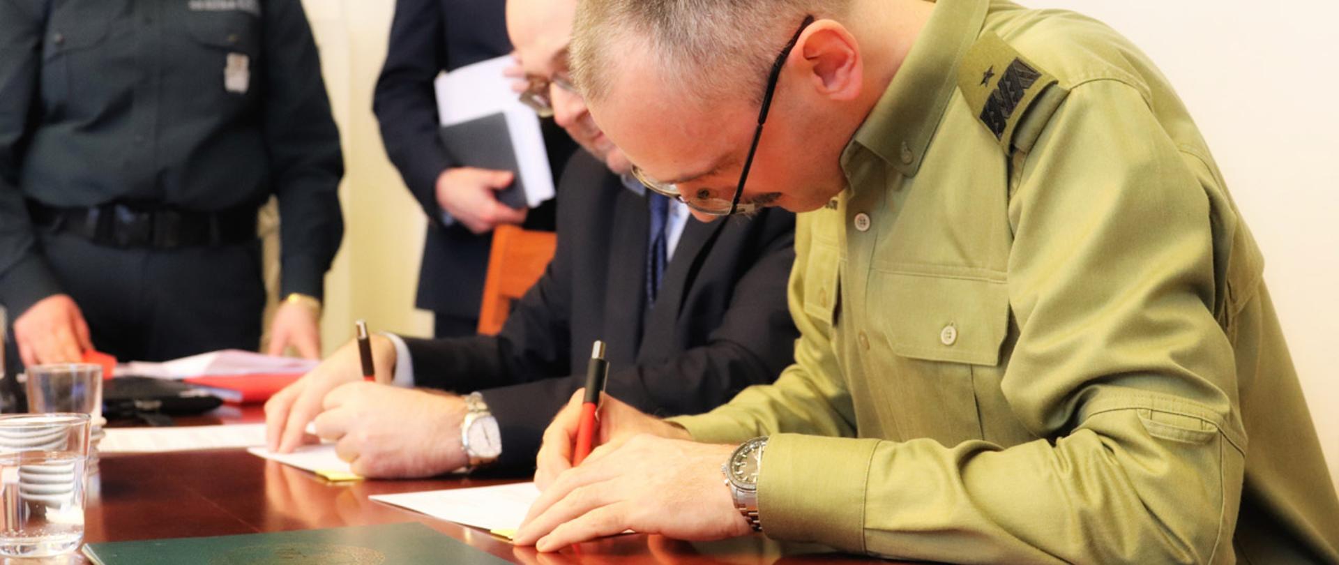 Z-ca Szefa KAS nadinsp. Piotr Walczak i Komendant Główny Straży Granicznej gen. bryg. SG Tomasz Praga podają sobie ręce po podpisaniu porozumienia o współpracy.