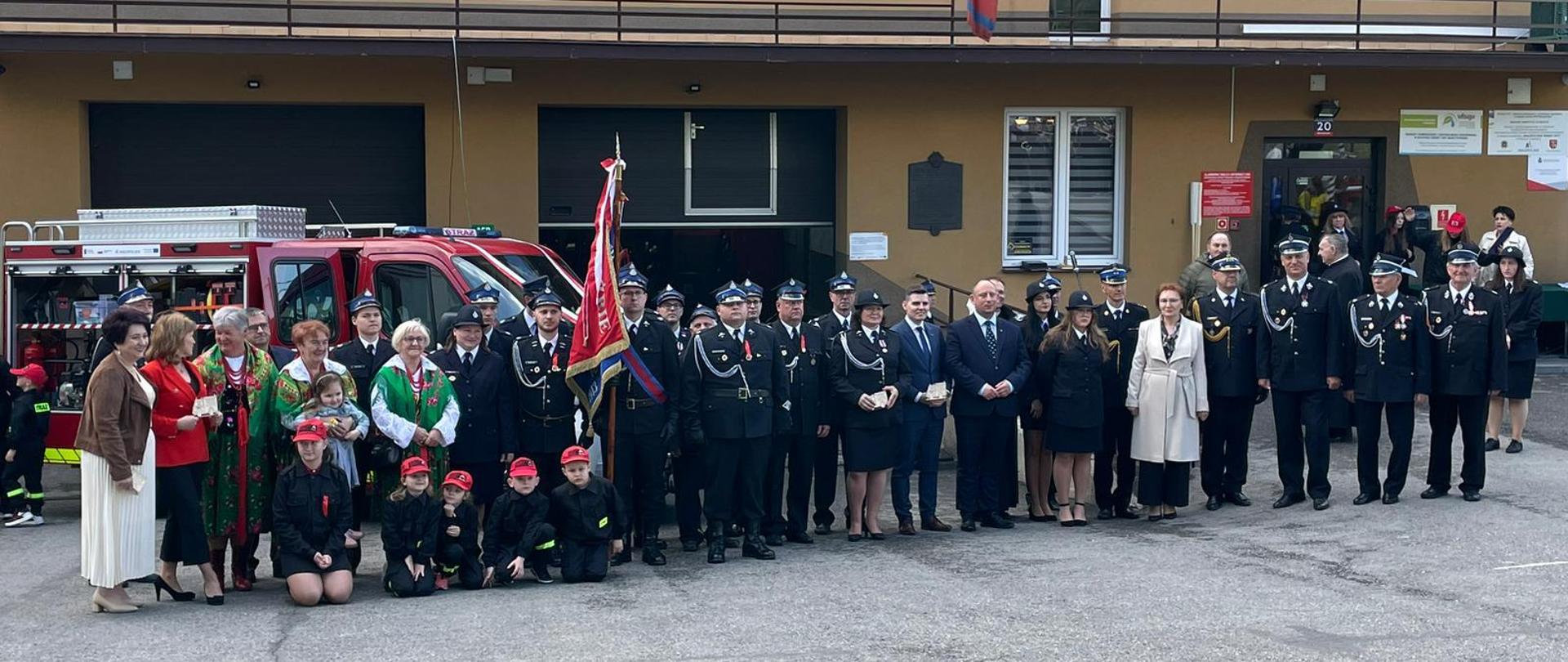 Widok z przodu. Na zdjęciu zaproszeni goście wraz z ochotnikami oraz dziećmi z MDP. W tle remiza OSP w Marcyporębie. 