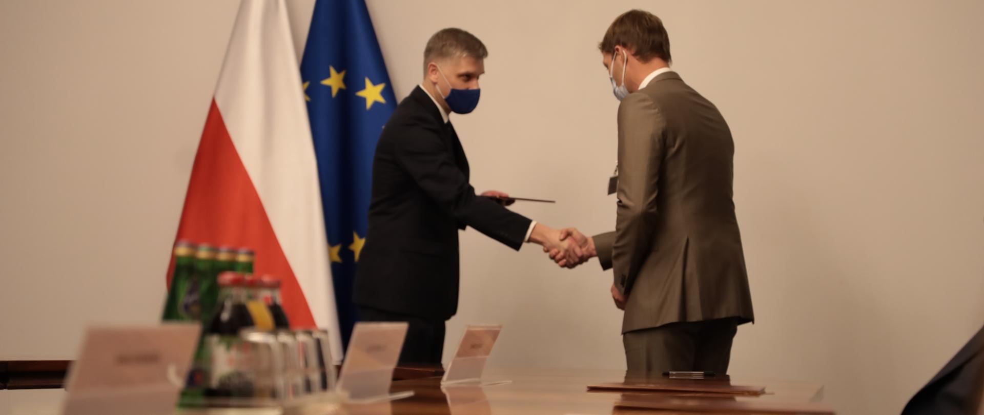 Minister Nowak ściska rękę i wręcza powołanie nowemu członkowi KIO.