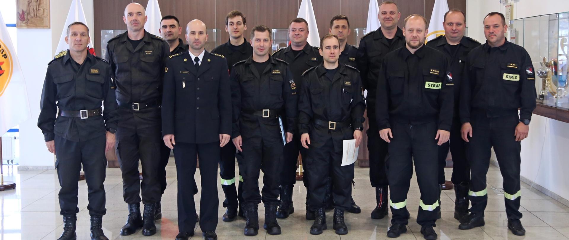 Grupowe zdjęcie uczestników warsztatów (12 osób) w towarzystwie Zastępcy Komendanta Centralnej Szkoły PSP