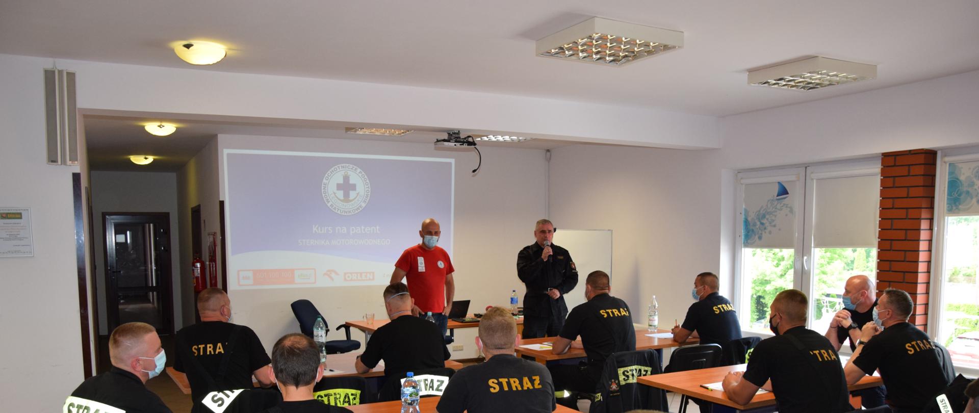 Strażacy na sali wykładowej podczas zajęć teoretycznych.