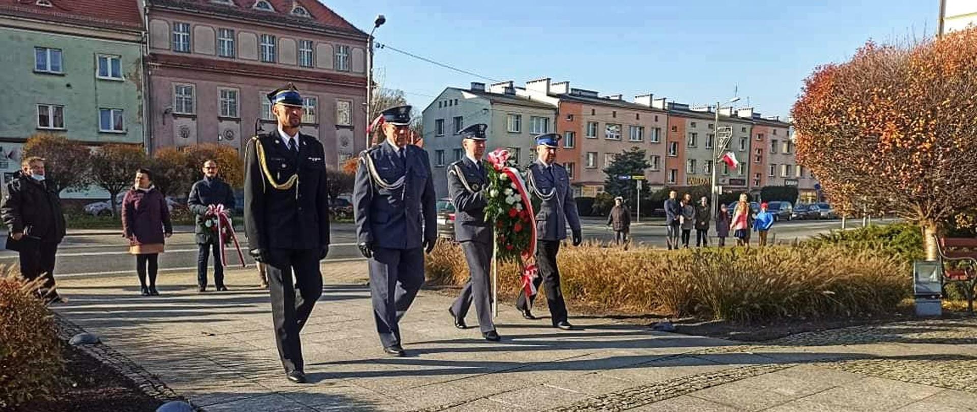 Na zdjęciu znajdują się przedstawiciele służb mundurowych powiatu strzeleckiego podczas składania wiązanki kwiatów pod pomnikiem Piety
