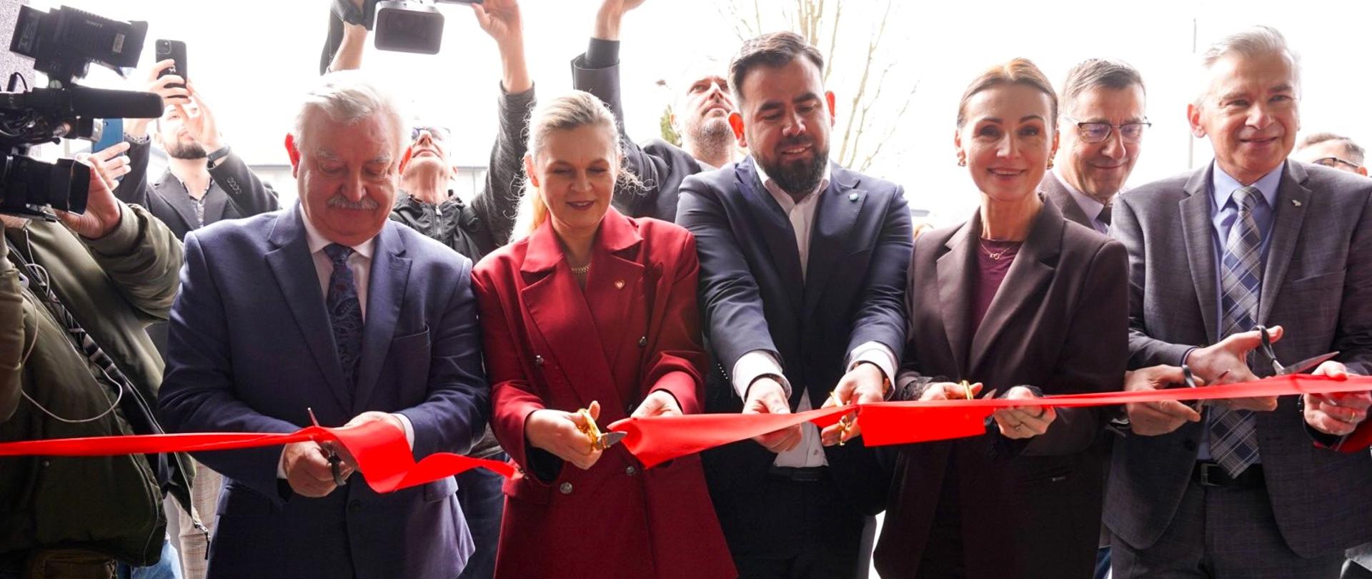 kilka osób przecina wstęgę