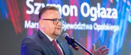 Na zdjęciu marszałek Szymon Ogłaza. W tle ścianka multimedialna.