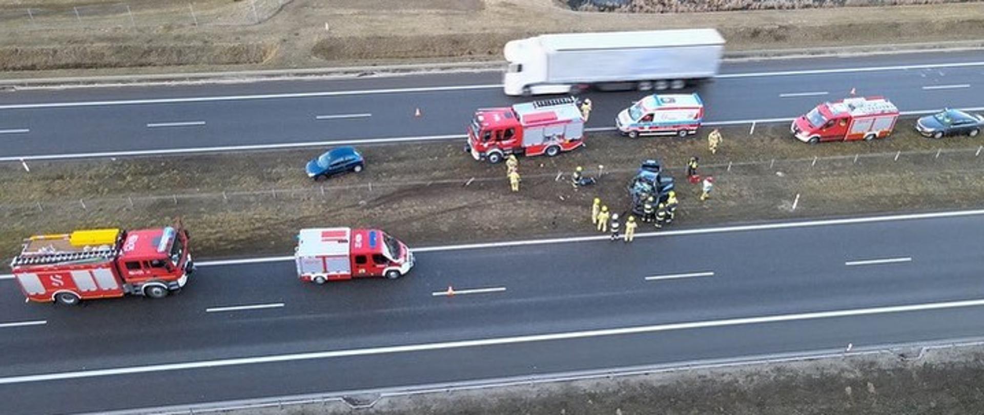 widoczne miejsce zdarzenia uszkodzone pojazdu oraz służby działające na miejscu.