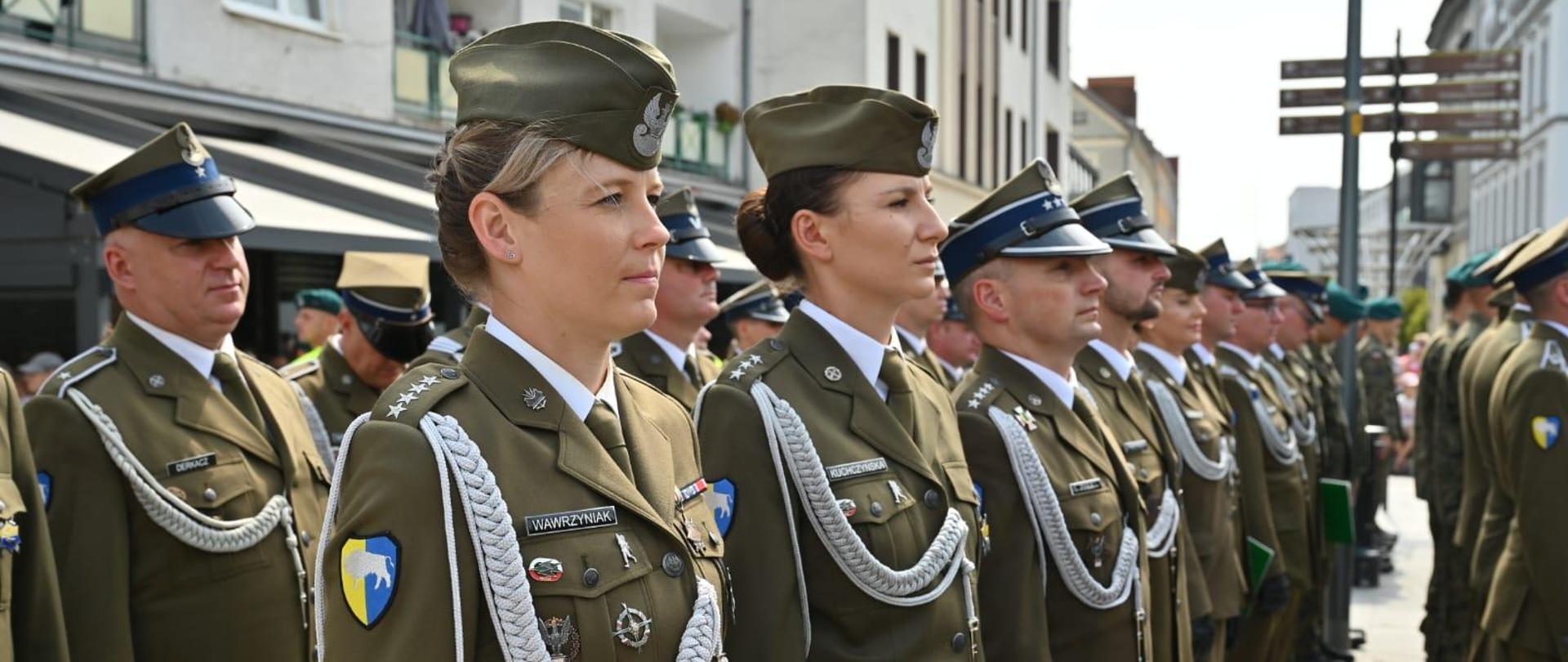 Żołnierze z 10 Opolskiej Brygady Logistycznej stoją w trakcie uroczystości. Na pierwszym planie widać kobietę. 