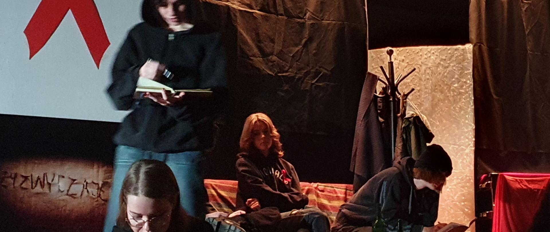 Zdjęcie - w centrum grupa młodzieży czytająca książki. 