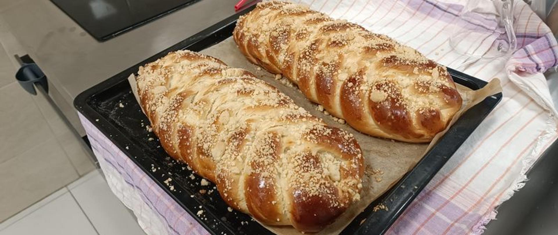 W szkolnej kuchni na blacie leżą świeżoupieczone chałki.