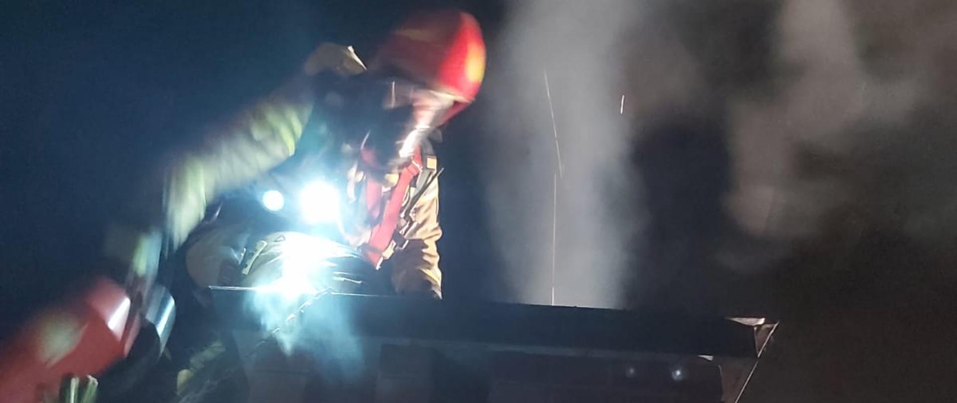 Strażak obok komina gasi pożar gaśnicą