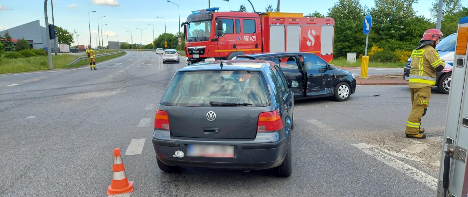 Widoczne miejsce zdarzenia uszkodzone pojazdy oraz strażacy prowadzący działania.