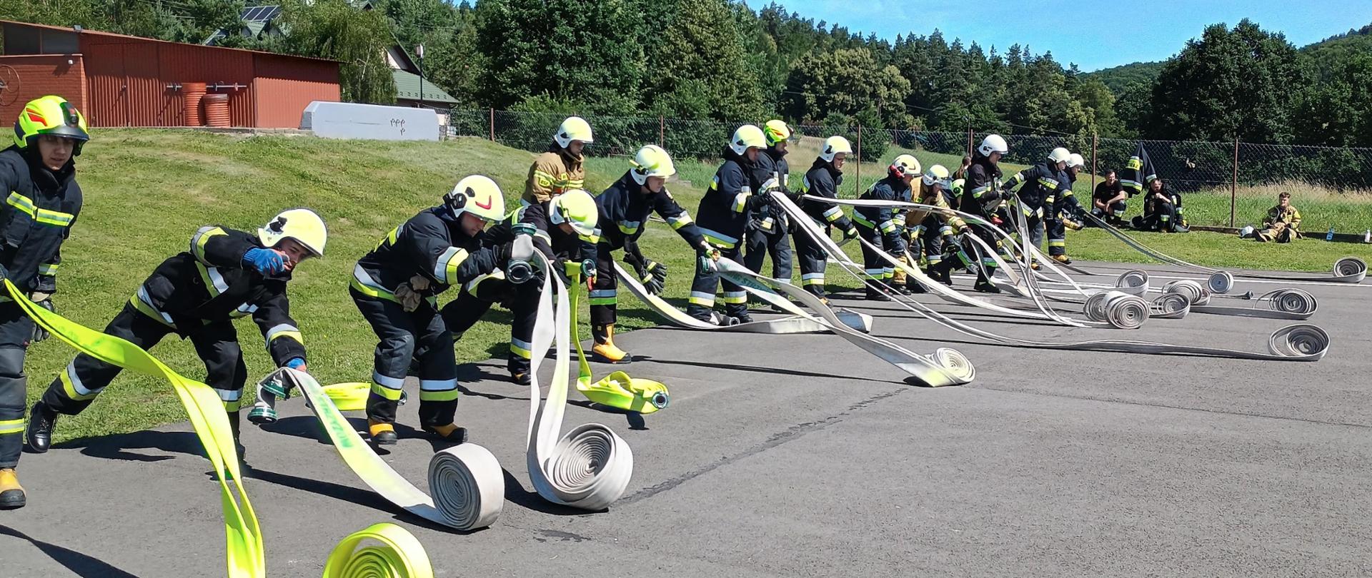 Na zdjęciu widoczni druhowie osp podczas ćwiczenia rozwijania węży