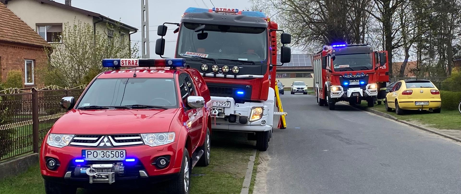 Wozy strażackie stoją na poboczu w pobliżu miejsca zdarzenia.
