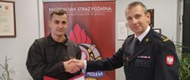 Awans na wyższe stanowisko służbowe - zdjęcie przedstawia Komendanta Powiatowego PSP w Brzegu oraz awansowanego strażaka.