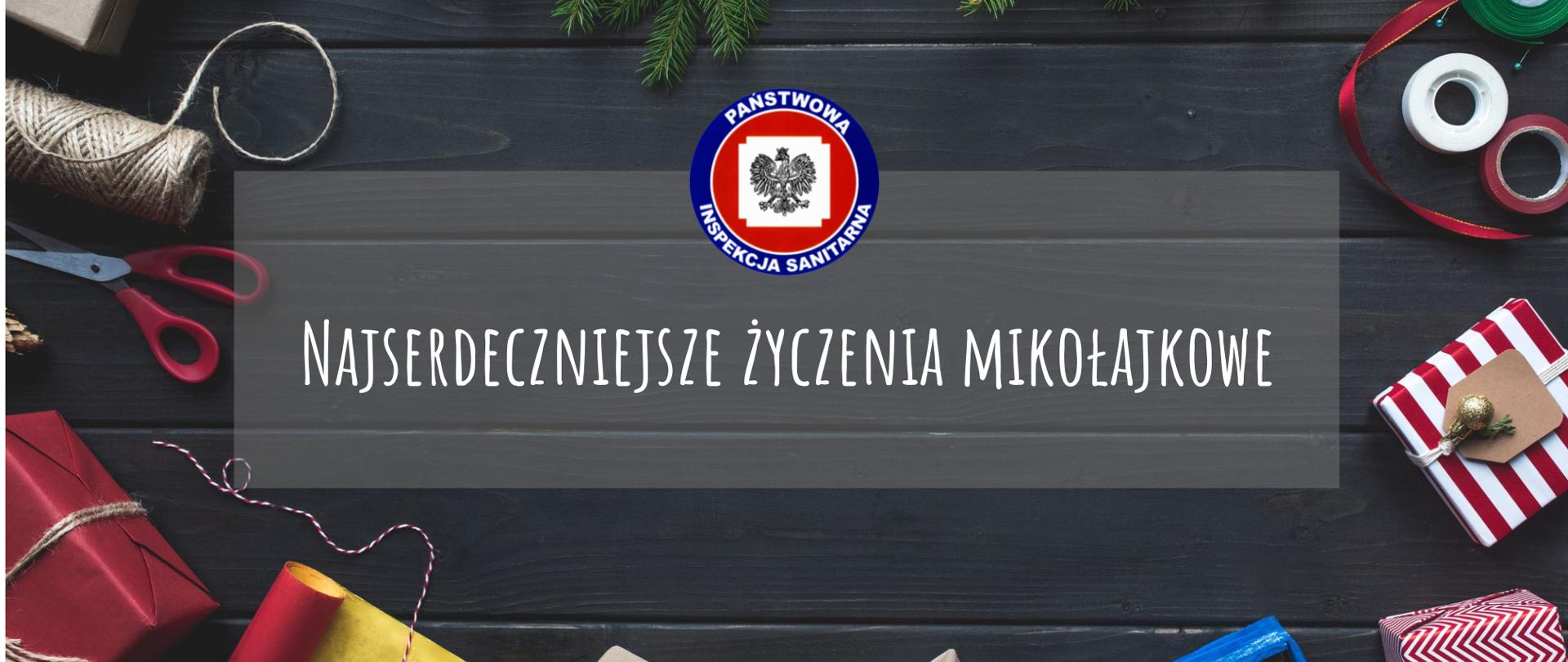 Na grafice widoczny jest świerk i prezenty oraz nożyczki i wstążki. W centrum jest logo Państwowej Inspekcji Sanitarnej i napis najserdeczniejsze życzenia mikołajkowe.