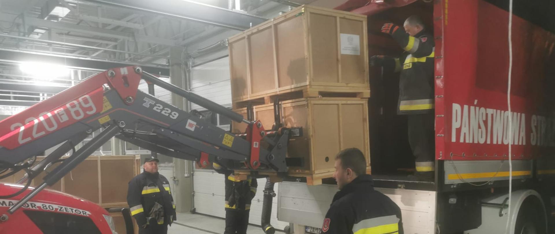 W jednostce PSP powiatu żagańskiego trwa załadowanie w sprzęt potrzebny na zorganizowanie punktu przyjęcia uchodźców z Ukrainy. Na samochód kwatermistrzowski ładowane są łóżka, koce, pościele i materace.