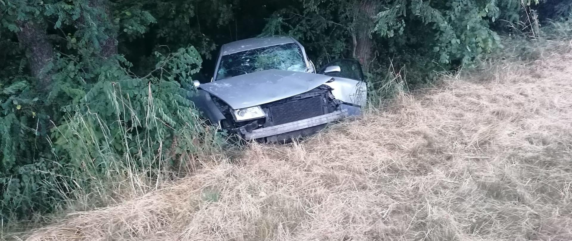 Widoczne miejsce zdarzenia uszkodzony pojazd który wypadł z drogi i znajduje się w przydrożnym rowie.