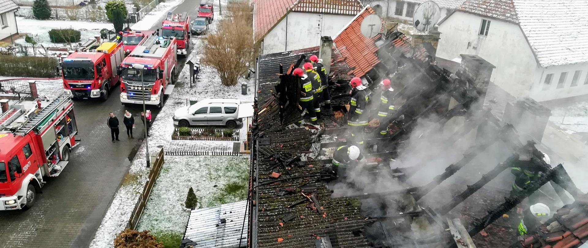 Zdjęcie przedstawia akcję gaśniczą z pożaru budynku wielorodzinnego