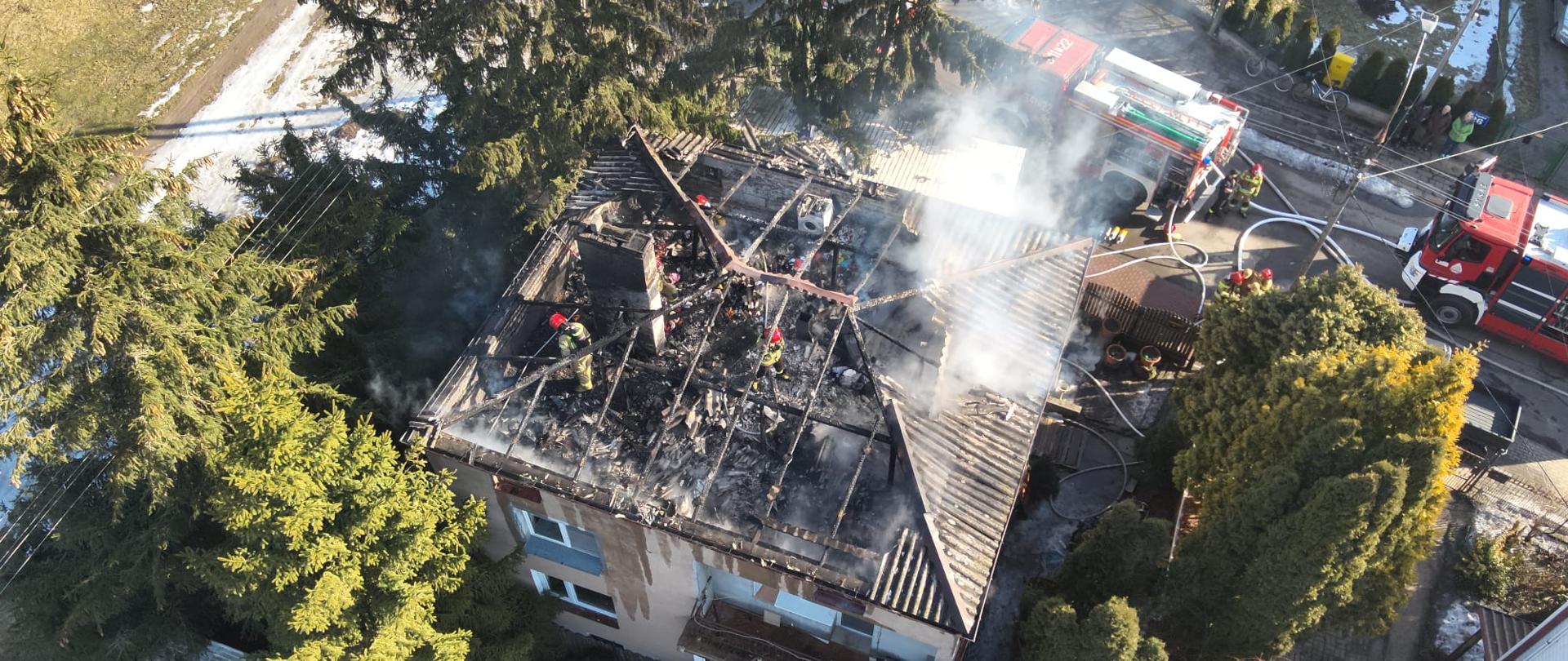 Zdjęcie z drona pracujących na poddaszu strażaków