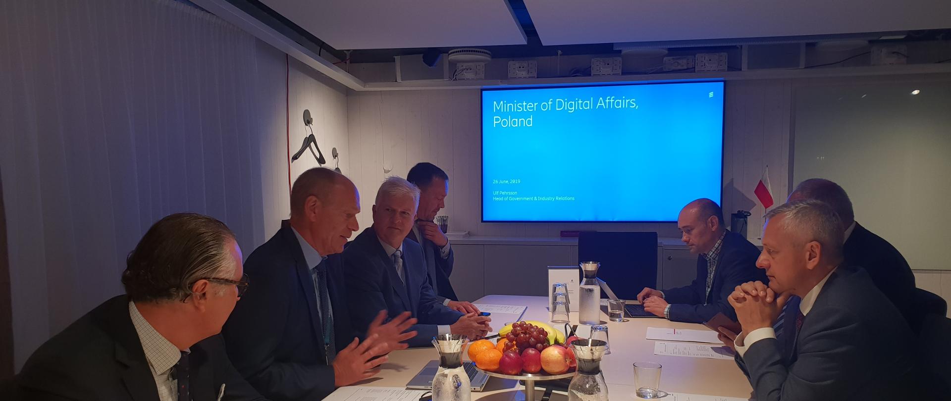 Kilkoro mężczyzn siedzi przy stole