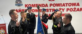 Zdjęcie przedstawia strażaków w ubraniu koszarowym, podczas ślubowania na sztandar.