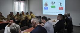 Podczas narady wyświetlana prezentacja, zgromadzeni na sali goście i strażacy