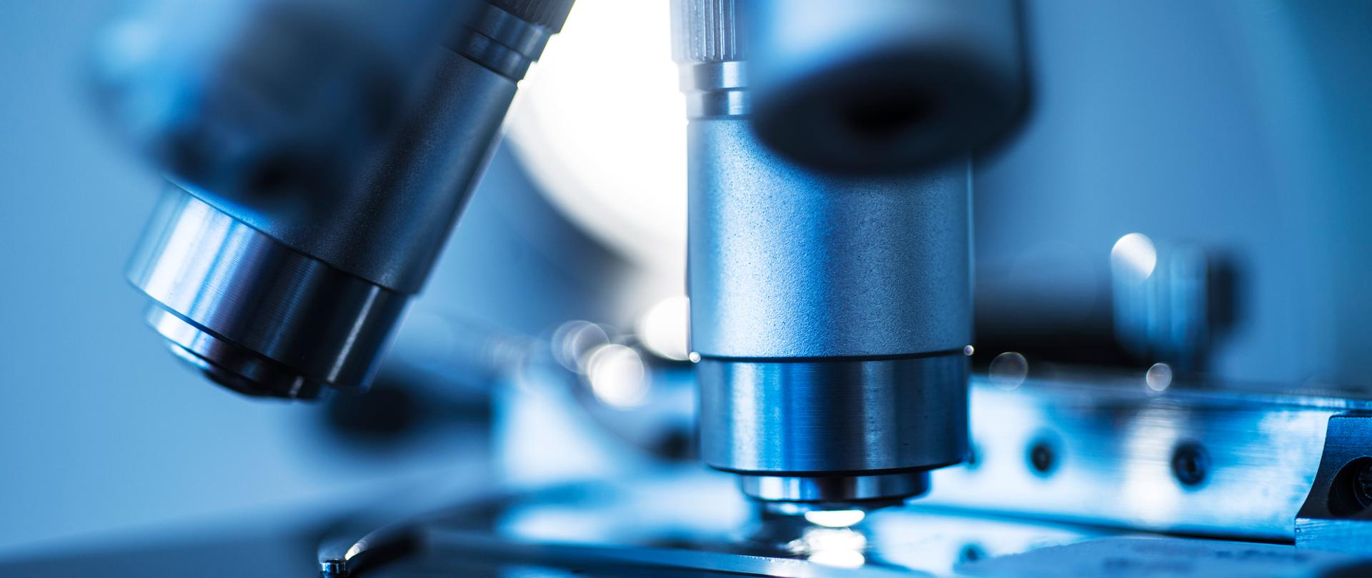 Selective focus of microscope lens on slide against colored background