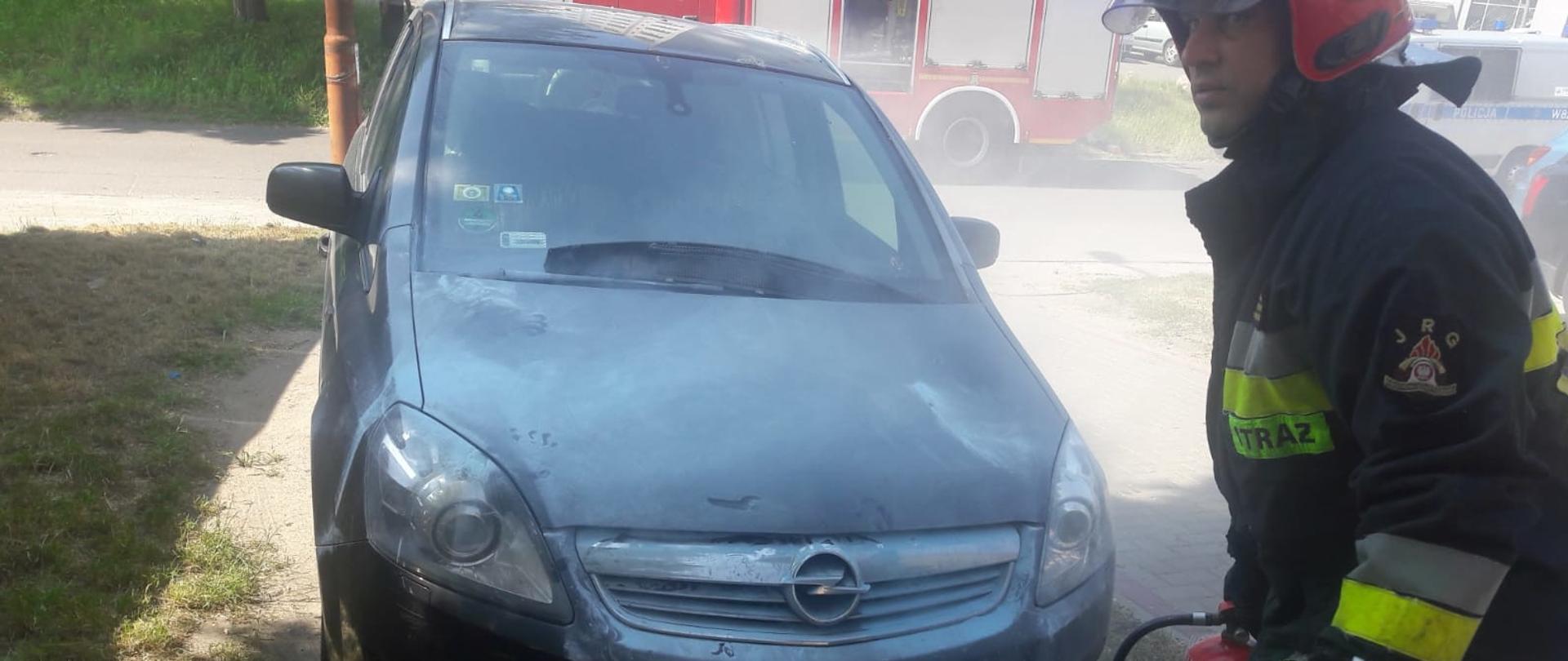 opel zafira obok strażak z gaśnicą proszkową