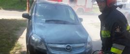 opel zafira obok strażak z gaśnicą proszkową