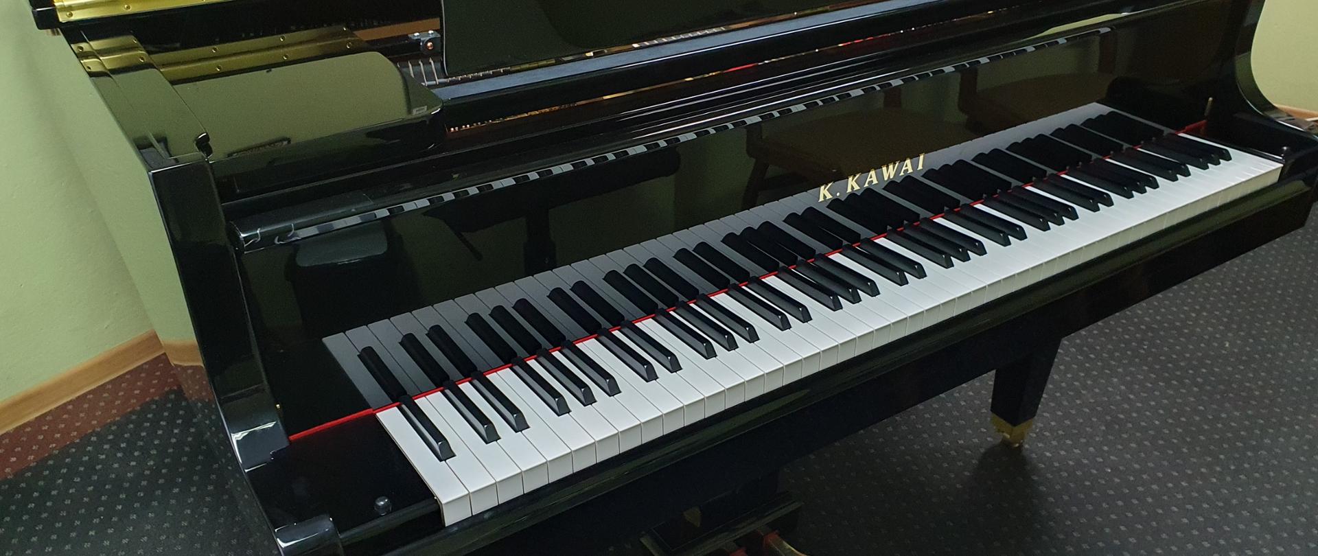 Klawiatura fortepianu i fragment fortepianu, widoczny napis K. Kawai