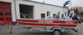 czerwona lódź z napisem straż pożarna stojąca przed budynkiem
