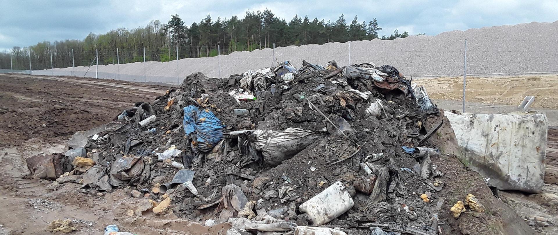 Odpady komunalne, budowlane i odpady mogące zawierać pozostałości substancji ropopochodnych (filtry olejowe) wymieszane z ziemią, porzucone na nieutwardzonym podłożu.