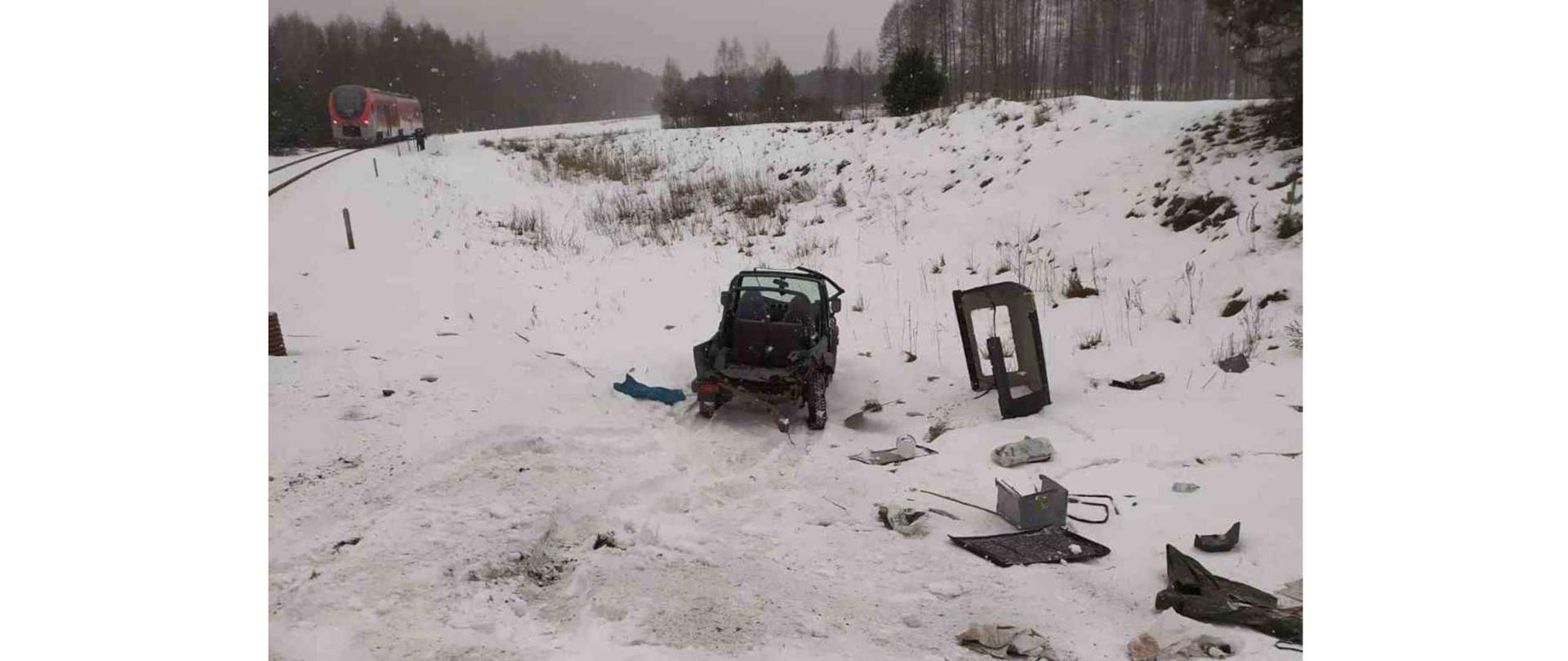 Pojazd osobowy po zderzeniu z szynobusem stojący w rowie przy torach. Na dalszym planie szynobus stojący na torach.
