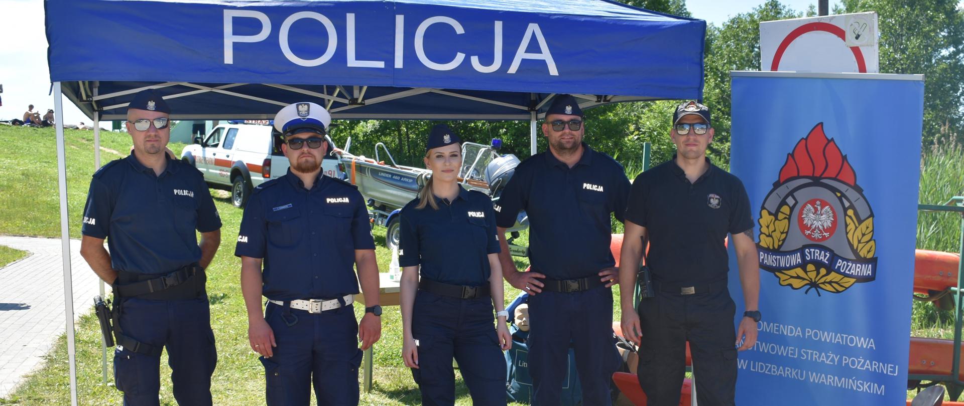 Zdjęcie przedstawia funkcjonariuszy Policji oraz Straży Pożarnej podczas zajęć profilaktyczno-edukacyjnych w ramach programu "kręci mnie bezpieczeństwo nad wodą"