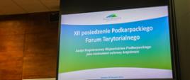 Ekran projekcyjny, na którym wyświetlana jest nazwa dwunaste posiedzenie Podkarpackiego Forum Terytorialnego. Poniżej widnieje napis: Audyt Krajobrazowy Województwa Podkarpackiego jako instrument ochrony krajobrazu.