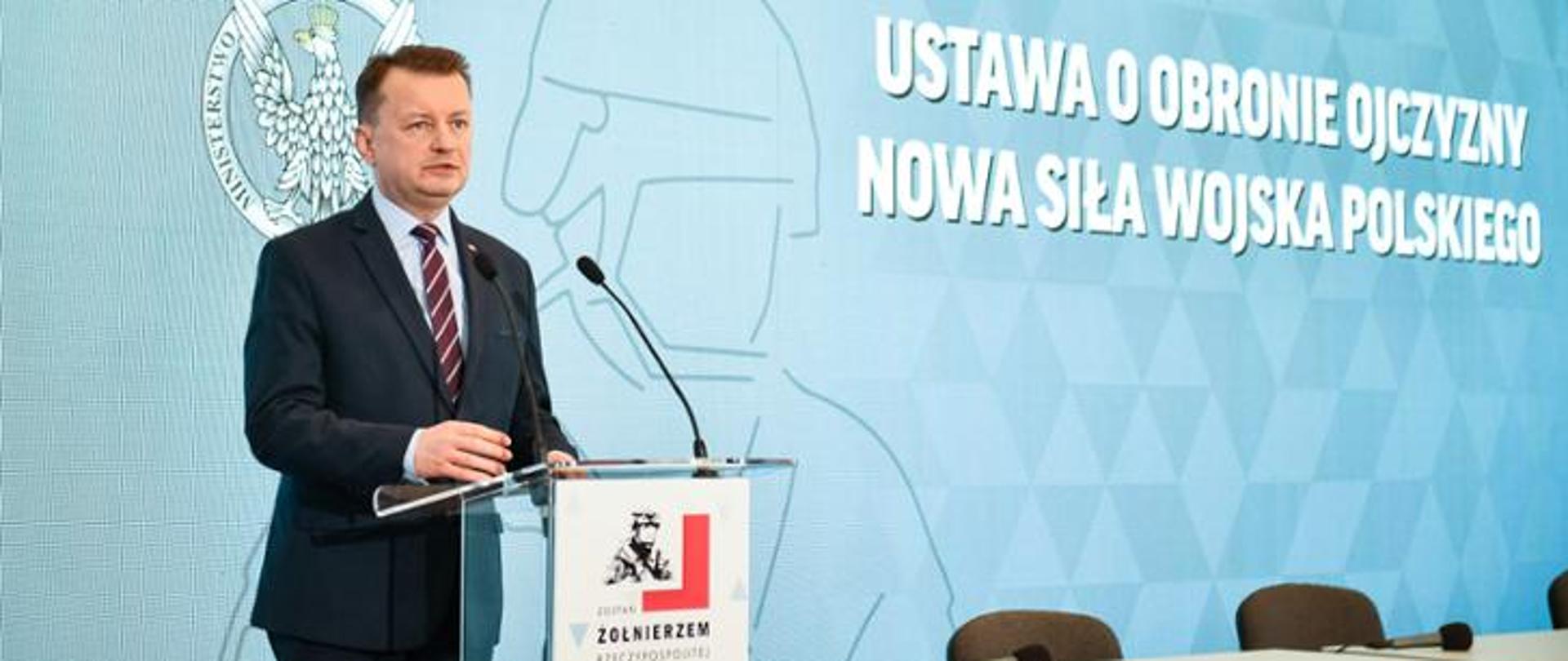 Jeden mężczyzna stojący przy mównicy i wypowiadający się