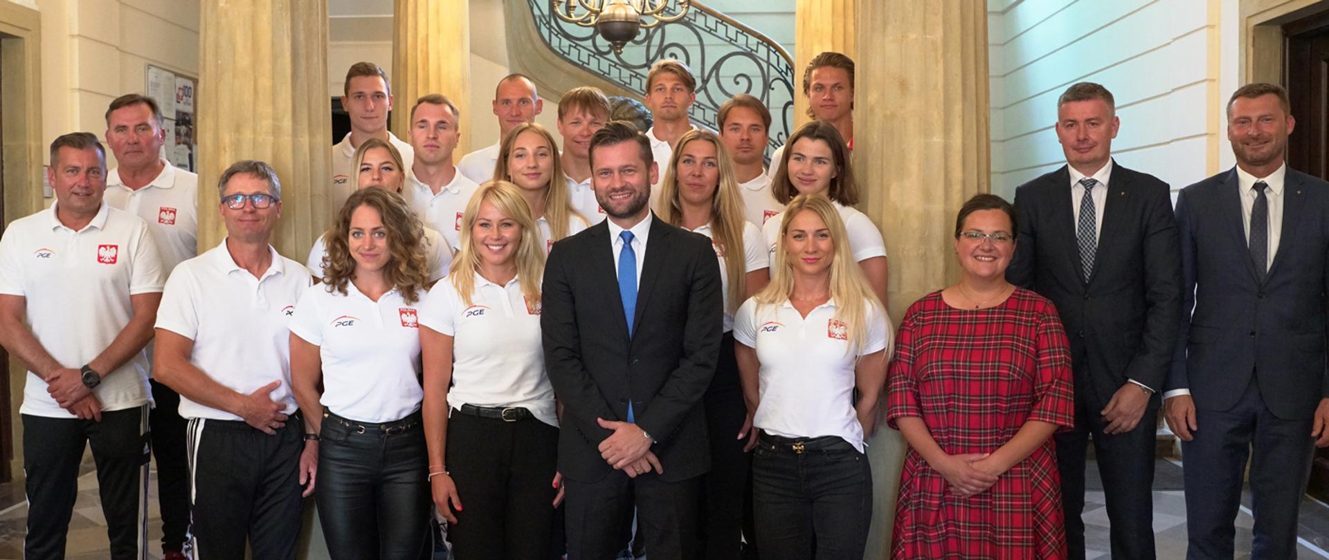 Spotkanie ministra Kamila Bortniczuka z medalistami Mistrzostw Europy w Kajakarstwie i Parakajakarstwie. Zdjęcie zbiorowe na schodach ministerstwa.