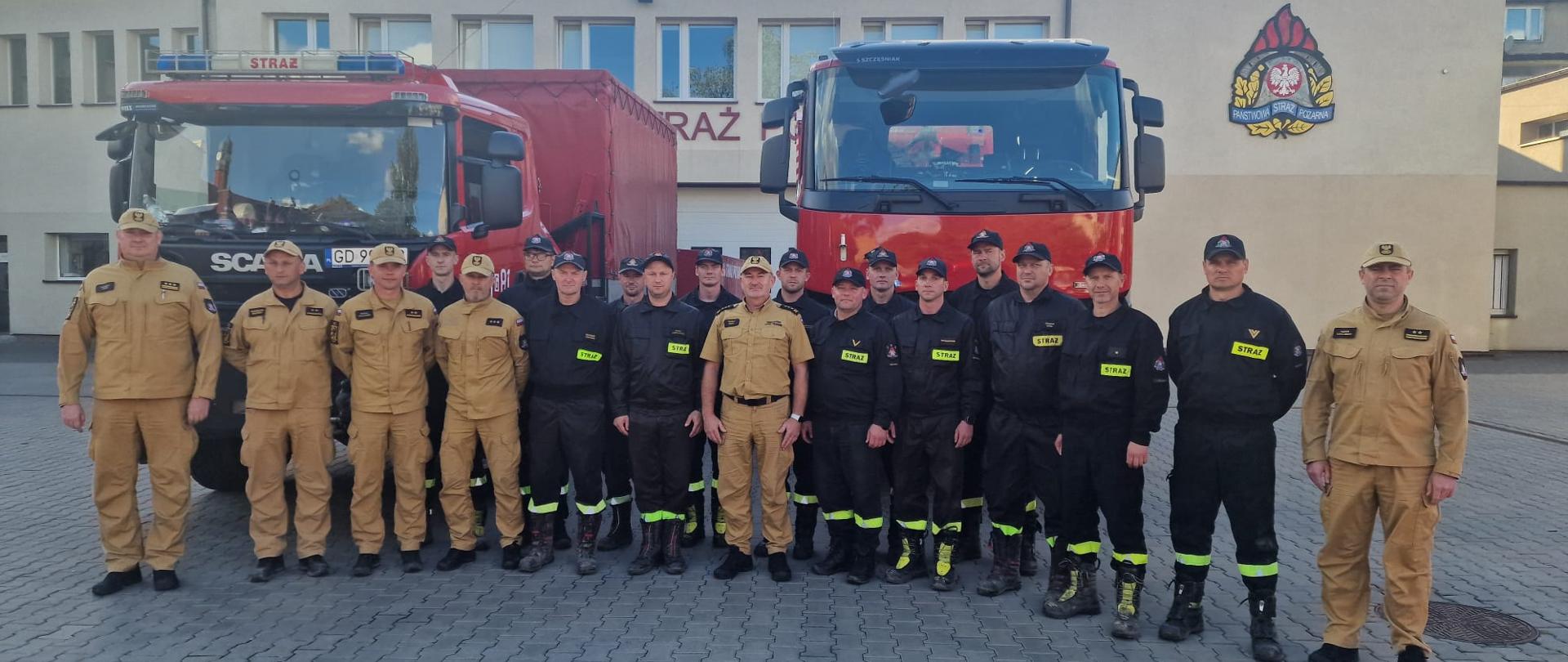 Zdjęcie grupowe strażaków kompanii z komendantami. W tle samochody strażackie i budynki JRG Tczew.