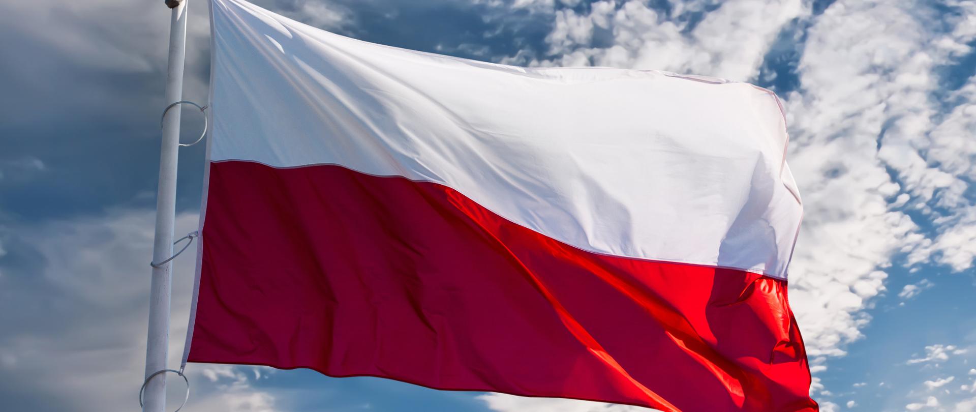 Na zdjęciu widać flagę Polski na tle niebieskiego nieba
