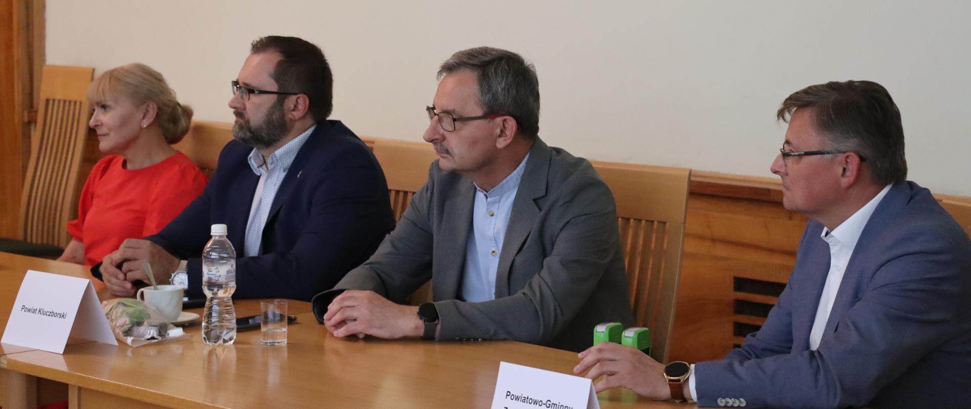 Cztery osoby siedzące przy stole. Od lewej siedzą pani wójt gminy Skoroszyce, przedstawiciele powiatu kluczborskiego i przedstawiciel Związku Transportu "Pogranicze".