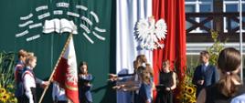 Na zdjęciu dzieci, składający ślubowanie, podczas uroczystej inauguracji roku szkolnego w otwocku. W tle budynek szkoły.