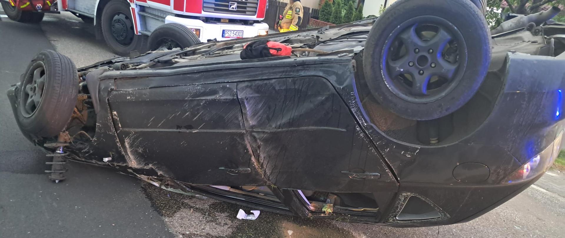 Samochód po dachowaniu na drodze, plama na drodze