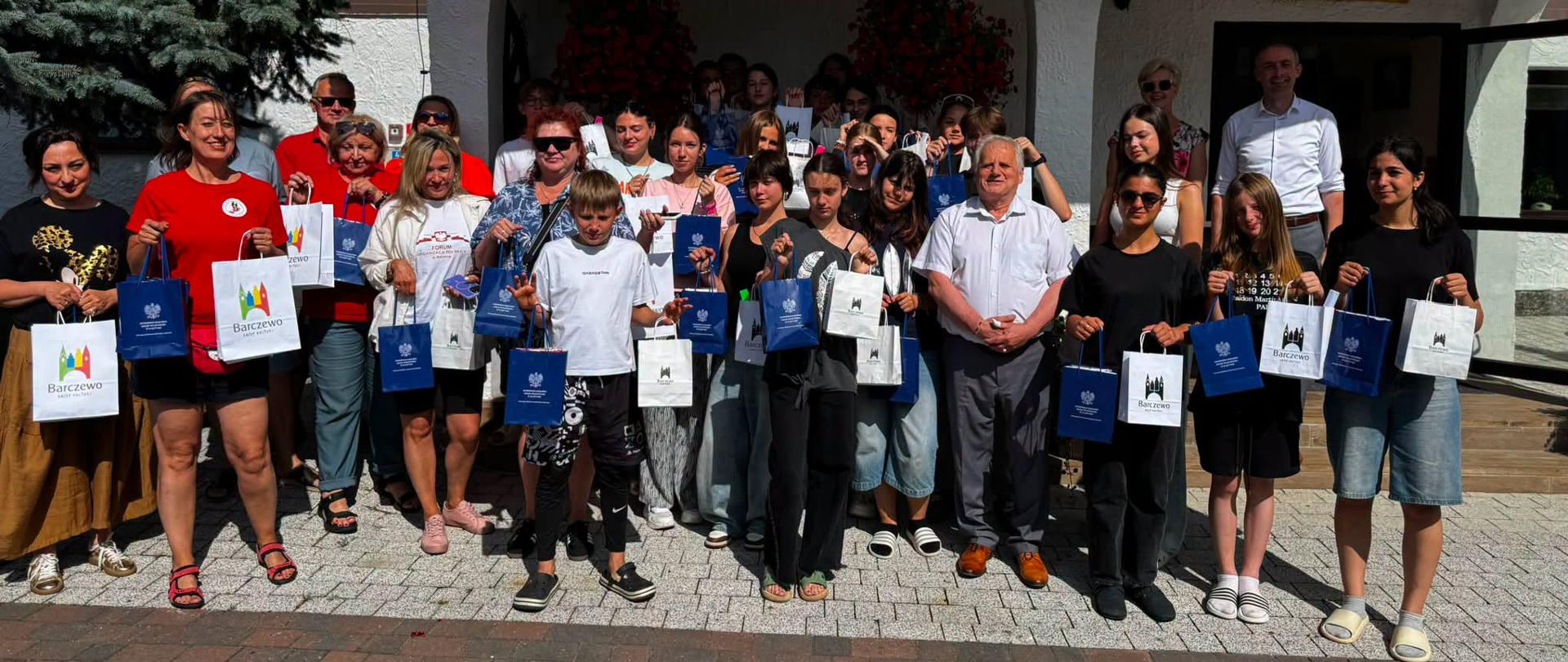 grupa dzieci pozuje do zdjęcia z mężczyzną w białej koszuli, wicewojewodą