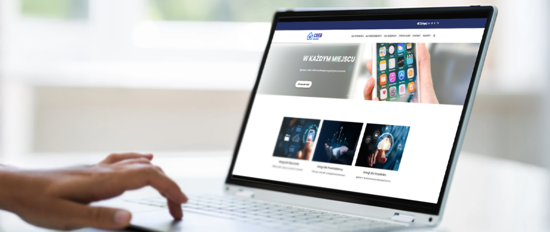 Strona internetowa Centralnej Ewidencji Emisyjności Budynków (CEEB) wyświetlona na ekranie laptopa, przedstawiająca informacje o nowym API do integracji zewnętrznych systemów z CEEB. Na ekranie widoczne jest hasło ‘W KAŻDYM MIEJSCU’, grafika z aplikacjami mobilnymi oraz trzy kafelki z ikonami symbolizującymi technologie cyfrowe.
