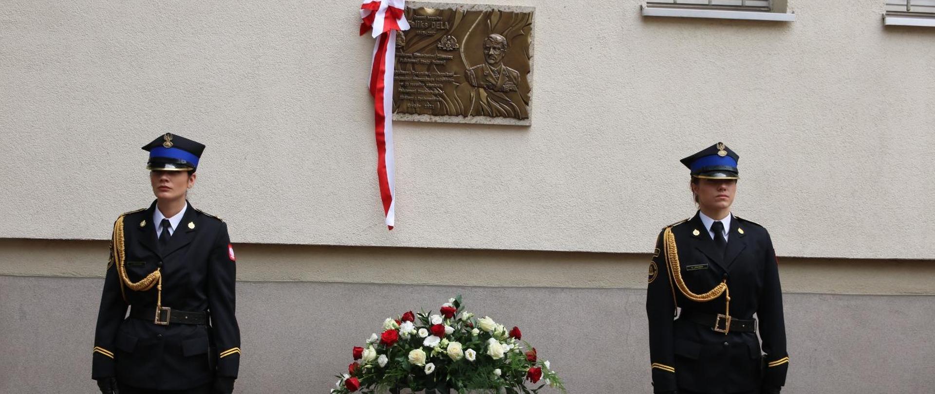 Dwie kadetki pełnia wartę przy tablicy pamięci gen. brygadiera Feliksa Deli umieszczonej na ścianie Szkoły Aspirantów PSP w Krakowie.
